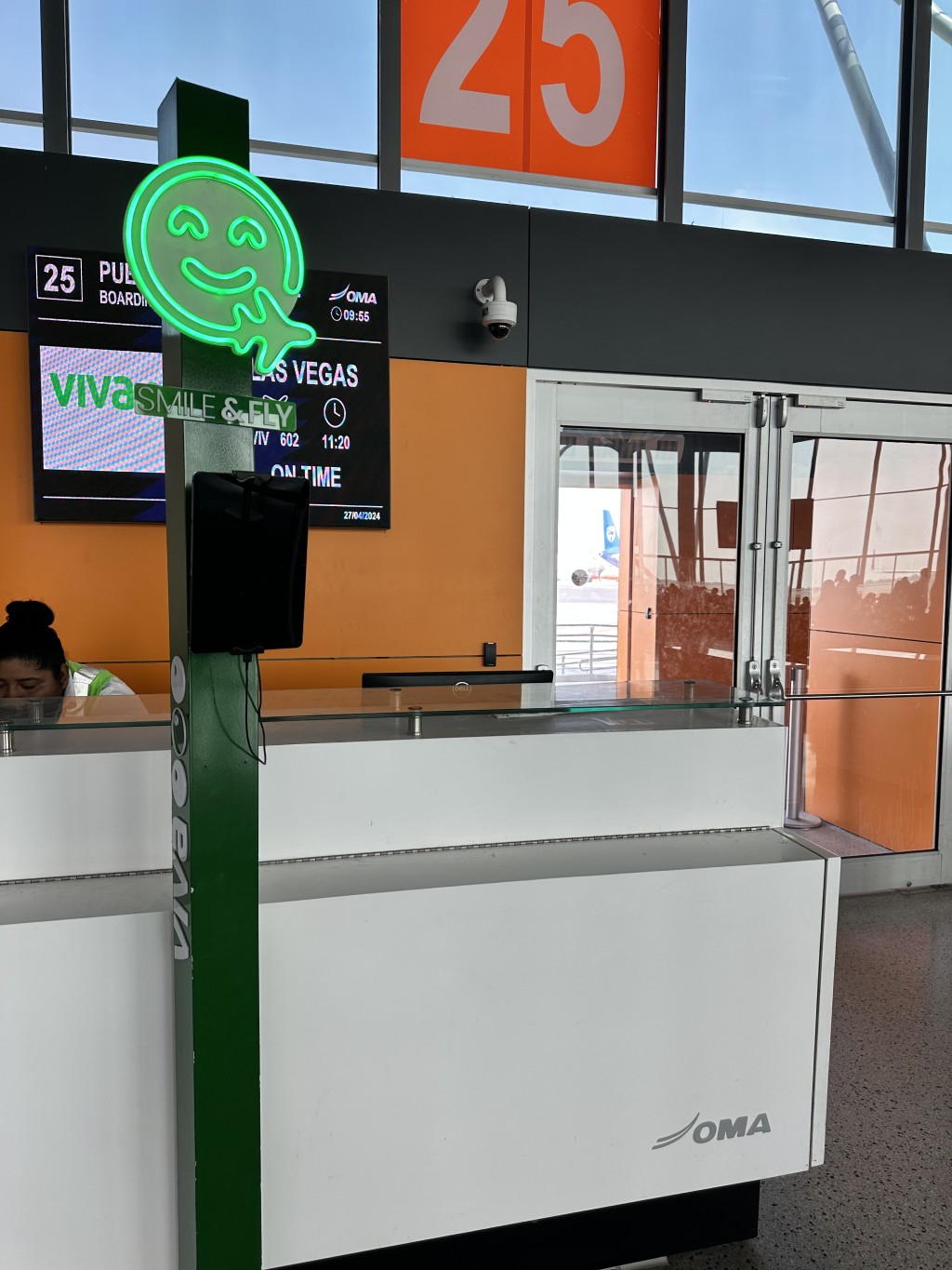 Green Fan ID kiosk beside an airport counter marked 23.