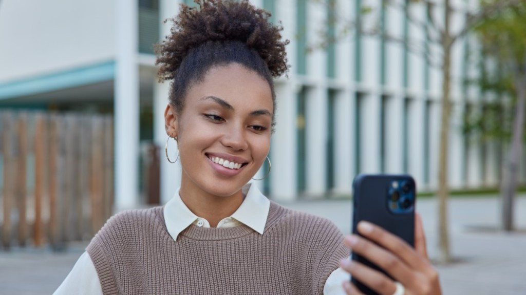 Woman using facial recognition for age verification on a mobile phone